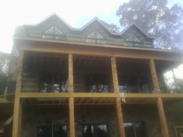 Dormers and porch framing on a large log home under construction — Roof Coating work by our crew in Monteagle