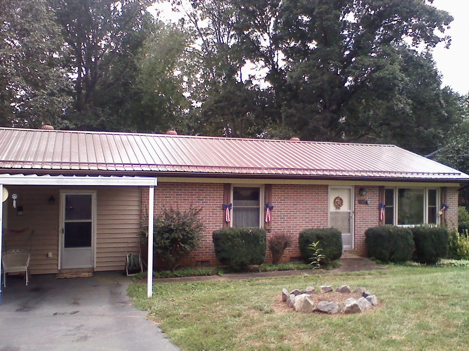 Bronze metal roof and carport on a brick ranch home — Roof Repair work by our crew in Monteagle