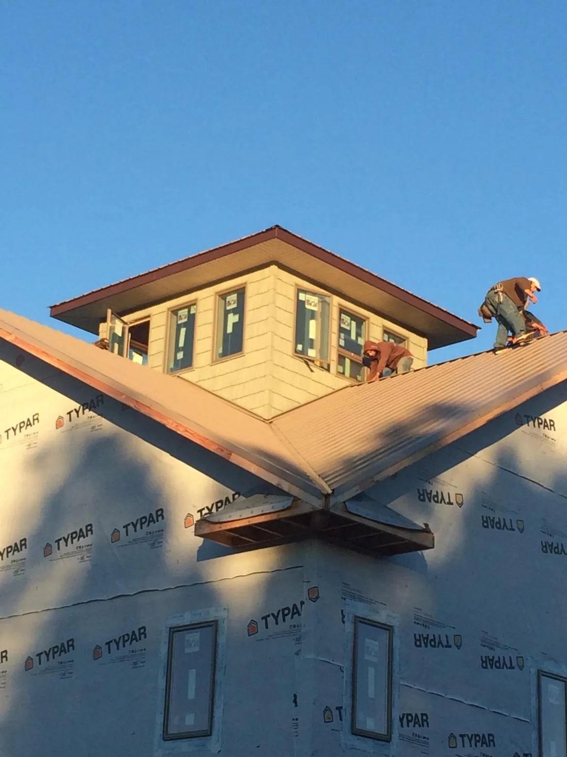 Roofers working around a rooftop cupola on a new metal roof at sunset — Roof Waterproofing in Monteagle by Roofing Brothers
